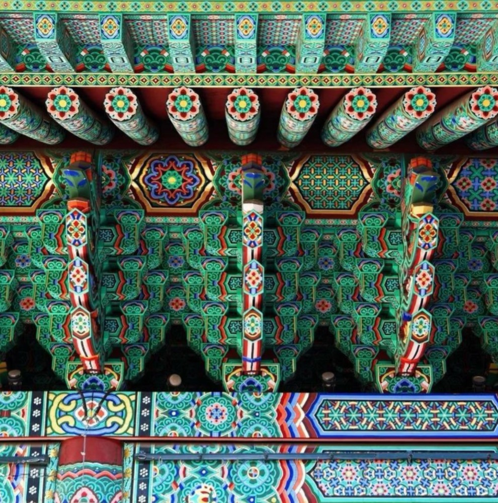 complex interlocking of green wood beams, part of a temple in South Korea